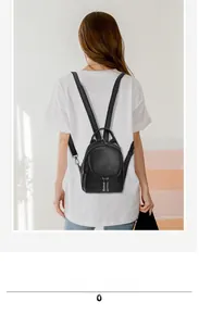 Detailed view of the black mini backpack with lychee texture and adjustable straps