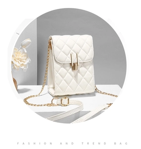 Detail shot of beige quilted crossbody bag featuring golden chain strap and U-shaped lock