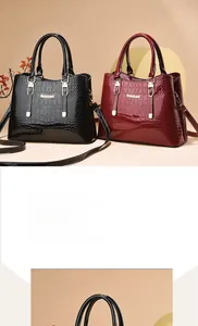 Close-up of glossy crocodile pattern patent leather tote with gold metal hardware