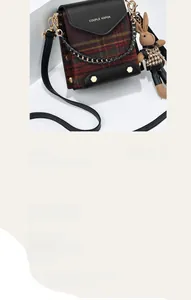 Detail of vintage plaid mini crossbody bag with a brown knit bunny charm and gold rivets