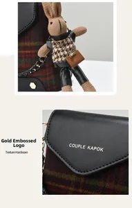 Detail of vintage plaid bag with gold-stamped logo and plush rabbit pendant charm