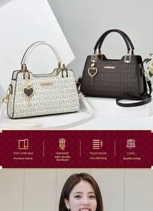 Detail of premium leather handbags with logo texture, hardware feet and heart charm