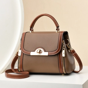 Brown and coffee leather crossbody bag with gold twist lock and rounded top handle