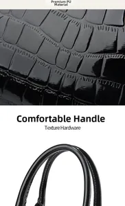 Macro detail of glossy crocodile pattern PU leather and stitched handle on black handbag