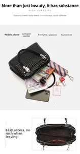 Macro view of black crocodile embossed handbag with high capacity interior and zip pocket