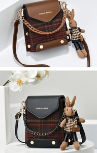 Detail view of British vintage plaid square bag with gold hardware and rabbit doll charm