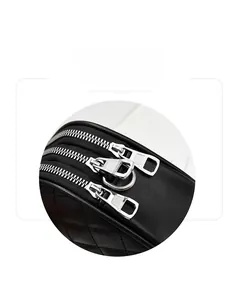 Close-up of black quilted leather bag with three silver zippers and metal pulls