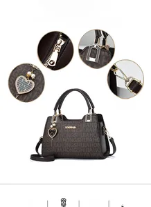 Detail view of coffee patterned handbag features golden logo and heart metal pendant charm
