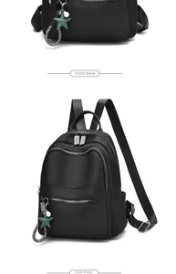 Detail view of black waterproof backpack featuring star pendant and smooth zipper texture
