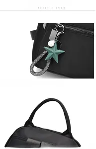Detail of black backpack showing pearl star pendant and durable webbing handle strap