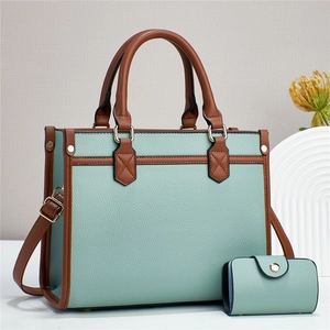 Detail of mint green tote and matching pouch set with brown straps and pebble texture