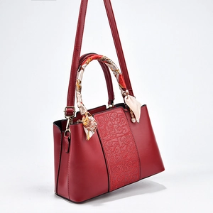 Elegant red bridal handbag with embossed pattern and silk scarf handle for weddings