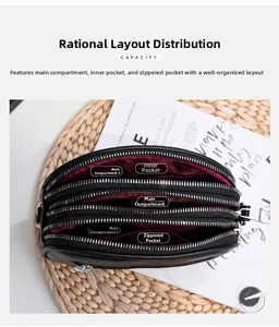 Internal view of black crossbody bag showing three main compartments and red fabric lining