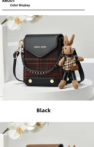 Detailed view of plaid crossbody bag featuring a cute bunny charm and metal chain