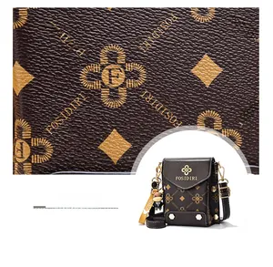 Détail du motif monogramme en cuir marron et breloque ours sur un mini sac à bandoulière