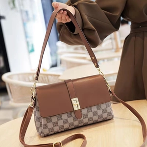 Detail of vintage brown jacquard shoulder bag with golden lock and leather texture