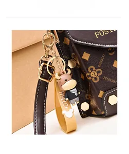Vue détaillée du mini sac de téléphone à motif monogramme avec breloque vache amovible