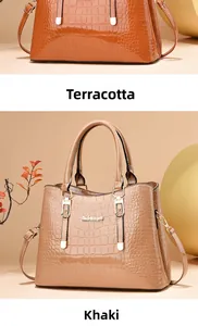 Detail of crocodile embossed patent leather tote bags in orange-brown and khaki colors