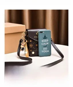 Détail d'un sac bandoulière marron foncé montrant la taille par rapport à un portable