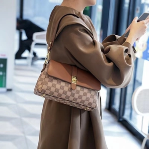 Retro shoulder bag with jacquard fabric and caramel leather trim on a female model