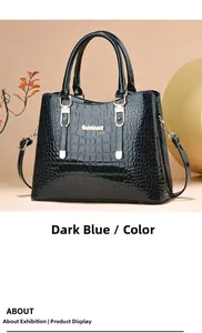 Detail of dark blue crocodile texture handbag with golden Gidebam logo and strap