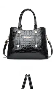 Detailed front view of black crocodile pattern handbag with gold Gidebam logo and handle