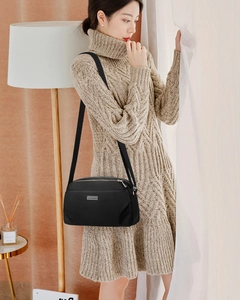 Detail of waterproof black nylon crossbody bag with multi-layer zippers and metal logo