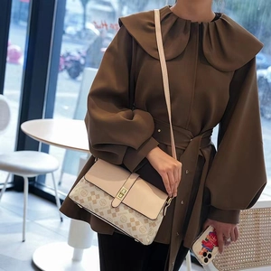 Detail of beige monogram print shoulder bag with a vintage square metallic lock buckle