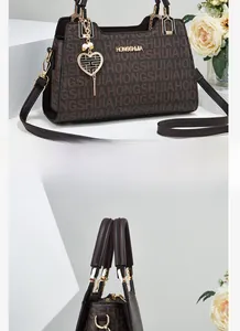 Detailed view of the dark brown satchel featuring floral patterns and a golden heart pendant