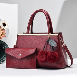 Elegant wine red handbag set with cherry pompom charm and matching envelope clutch