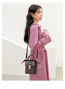 Detail of checkered crossbody bag with gold twist lock and scarf-wrapped handle