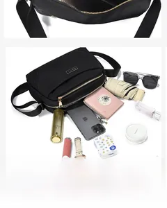 Detailed view of black nylon crossbody bag showing multiple pockets with daily essentials