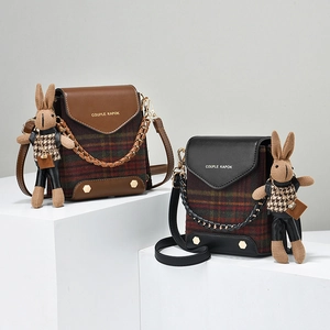 Retro plaid crossbody bag with leather flap and cute rabbit doll charm accessory