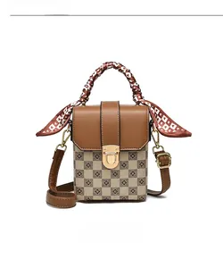 Close-up of a mini crossbody bag with checkered pattern and silk-wrapped handle detail