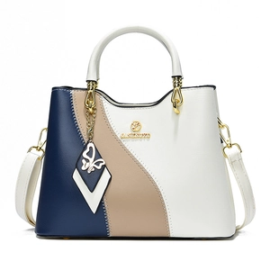 Sac à main bicolore avec logo doré, pendentif papillon et bandoulière amovible