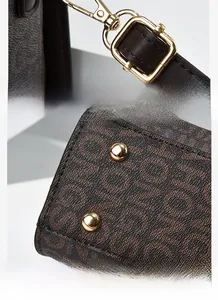 Detail of gold-plated hardware and anti-slip bottom rivets on brown monogram tote bag
