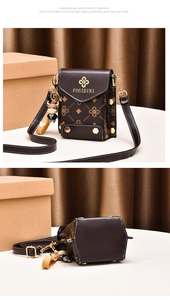 Détails d'un mini sac bandoulière en cuir marron avec motifs et pendentif vache