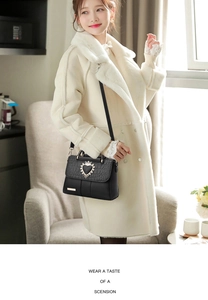 Detail of black faux fur coat outfit paired with crocodile embossed heart handbag