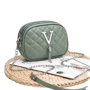 Green quilted faux leather crossbody bag with triple zippers and silver V logo detail