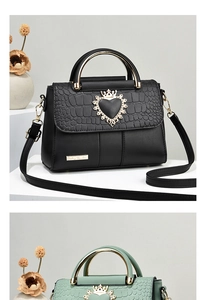Detail of luxury crown heart buckle and crocodile texture on stylish leather handbag