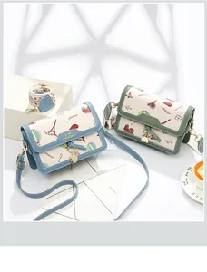 Detail of travel pattern crossbody bags with Eiffel Tower print and gold metal charms