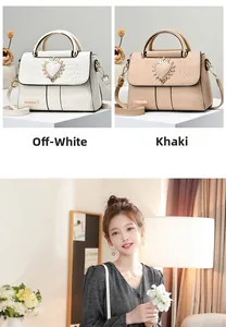 Detail of elegant heart crown rhinestone buckle on crocodile embossed leather handbag