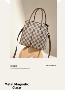 Detailed macro view showing the secure metal magnetic closure on this retro checkered bag