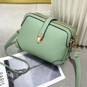 Dettaglio della borsa a tracolla verde menta con texture litchi e cerniere dorate