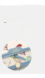 Close-up of Eiffel Tower and hot air balloon prints on beige leather crossbody bag