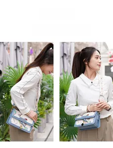 Detail of adjustable floral strap and Eiffel Tower print on a blue square crossbody bag