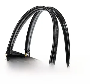 Detail of glossy patent leather handles with precise stitching on a black handbag