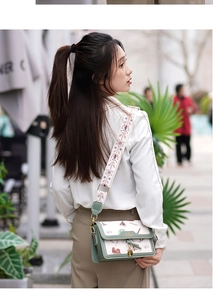 Detail of crossbody bag with embroidered wide strap and vintage illustration print