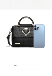 Detail view of black crocodile pattern handbag showing large capacity for essentials