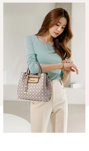 Close-up of beige vintage monogram handbag with woven handle and gold hardware detail